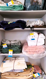 Bedding and curtains folded on shelves