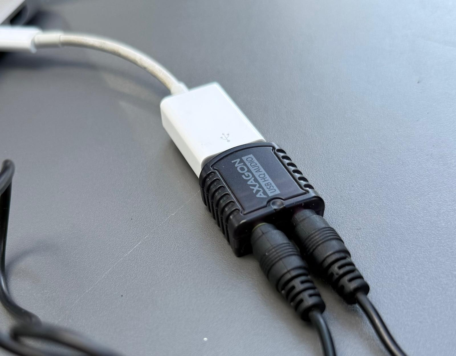 Audio cables plugged into my MacBook, via an external soundcard dongle