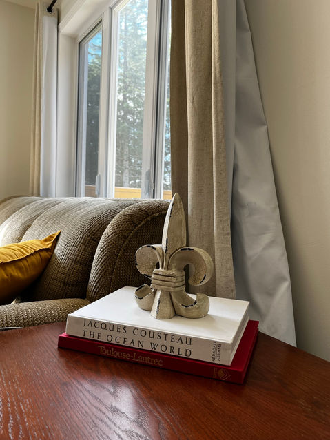 fleur de lis atop 2 coffee table books on Jaques Cousteau and Toulouse Lautrec
