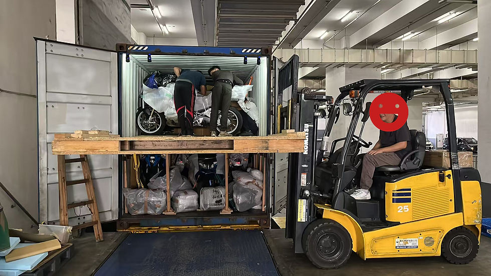 People load wrapped motorcycles into a shipping container in a warehouse. A person operates a yellow forklift marked "25."