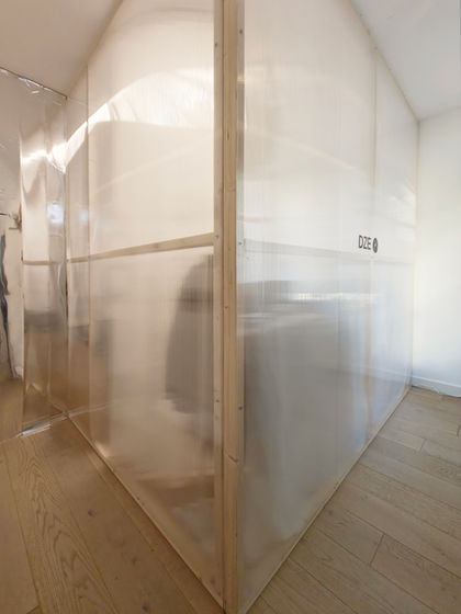 Amsterdam mixed-use interior design featuring a light-filled apartment and working studio with custom furniture, wood and polycarbonate elements, and reflective partitions.