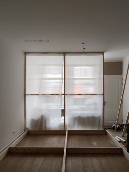 Amsterdam mixed-use interior design featuring a light-filled apartment and working studio with custom furniture, wood and polycarbonate elements, and reflective partitions.