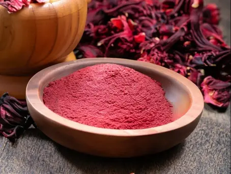 Image showcasing hibiscus in both its natural flower form and finely ground powder, highlighting its transformation from raw botanical to a versatile ingredient used in food, beverages, and cosmetics.