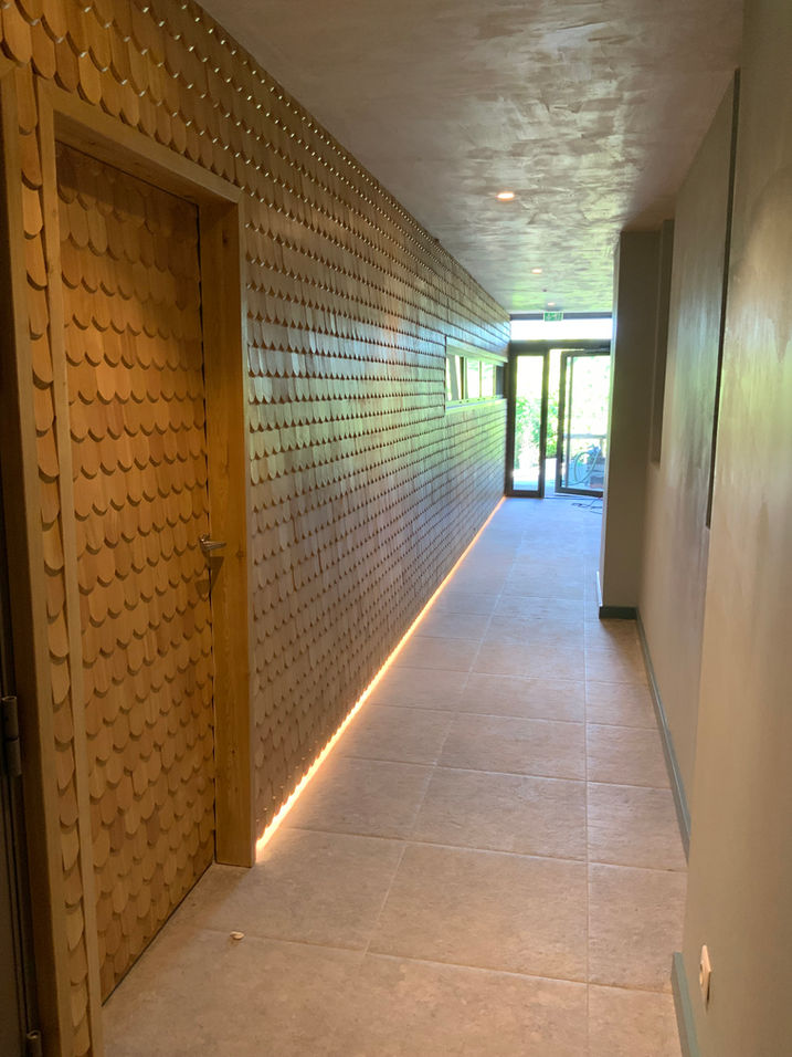 Couloir lumineux avec murs en bois et porte