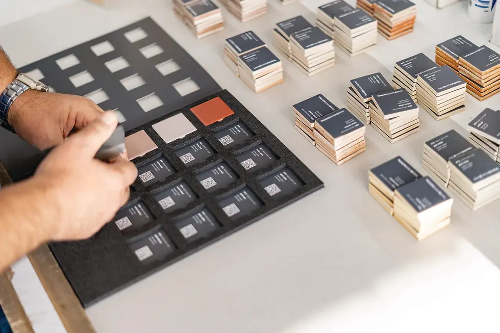 Person arranging tile samples with text, architectural tile supplier UK, Spectile.