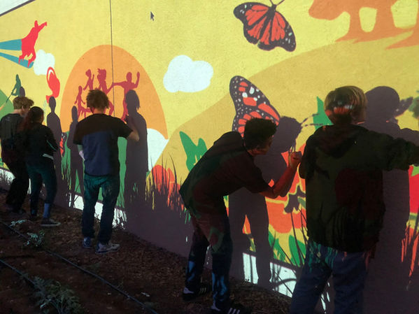 Edificio Pacific Apparel con jóvenes artistas pintando el nuevo mural