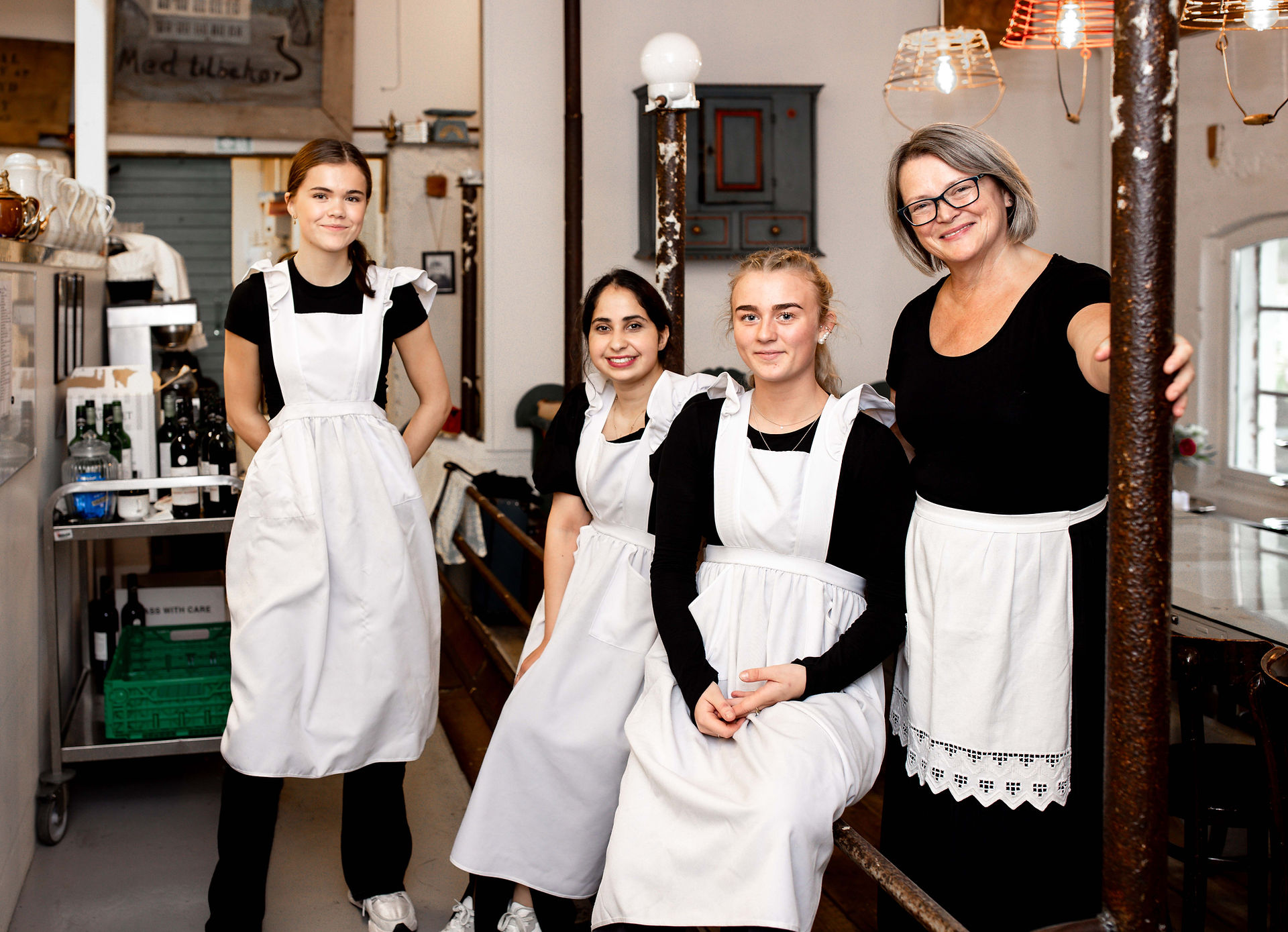 Fire ansatte i selskapslokaler smiler