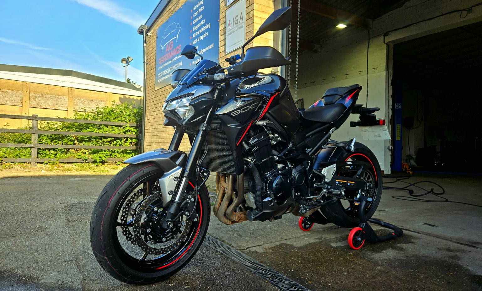 Actual Kawasaki motorcycle outside AG Performance garage signage