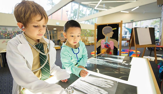 Children dressed up as doctors looking at xrays