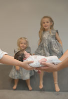 newborn at focal point with the two older sisters in background