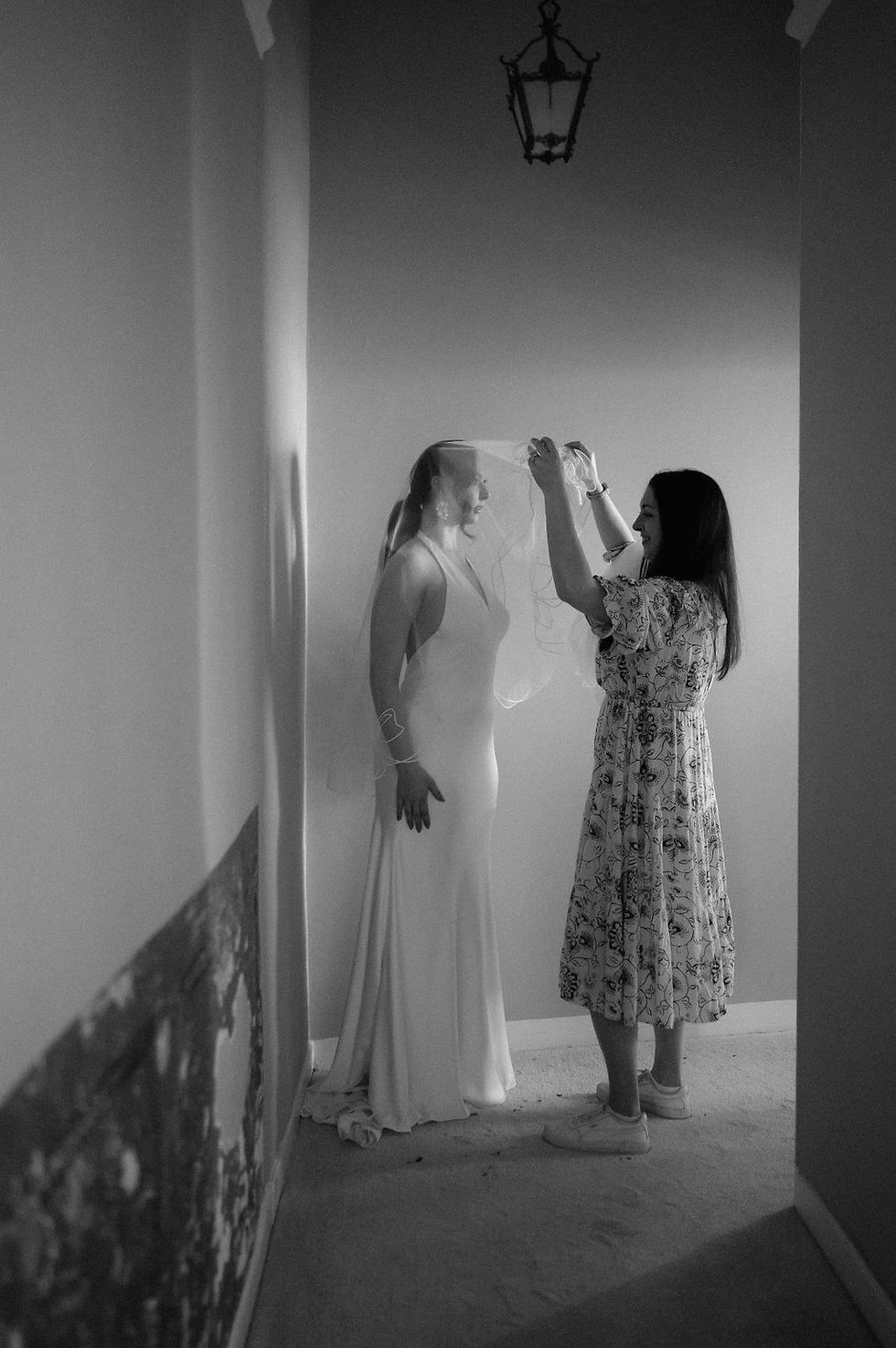 Rebecca Anne fitting a bride’s bespoke embroidered veil, illustrating how to wear and secure a wedding veil for an elegant, timeless bridal look.
