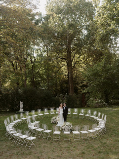 Wide-angle view of circular outdoor ceremony setup with couple at centre, capturing modern romantic styling and sustainable wedding design.