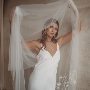 Modern bride wearing a long embroidered veil with delicate floral stitching by Rebecca Anne Designs, capturing the fluid drape and artistry of bespoke veil design.