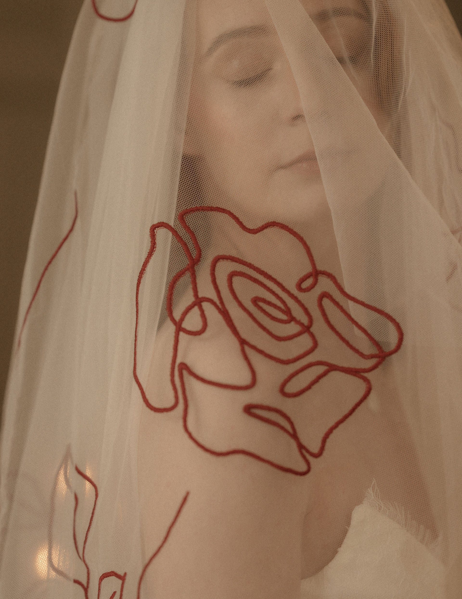 Close-up of a bold red-embroidered floral design on a veil, showcasing a unique way to customise your embroidered wedding veil with vibrant colour accents.