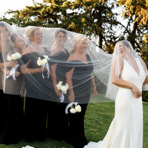 Real bride Charley laughing with her bridesmaids beneath a flowing tulle veil — natural wedding veil photography capturing candid, joy-filled moments.