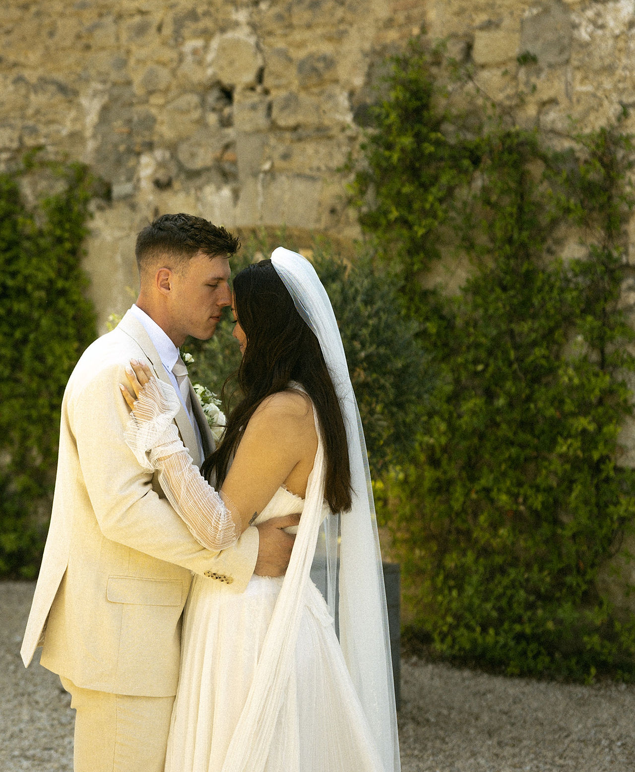Bride and groom share a quiet moment, with the bride wearing a custom veil featuring handwriting embroidery on a veil for a sentimental and elegant wedding day detail.