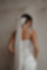 Bride wearing satin bridal hair bow with long ribbon tails, elegant wedding veil alternative with minimalist styling