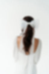 Back view of bride wearing oversized tulle bridal bow with long tails, statement veil alternative for modern bride