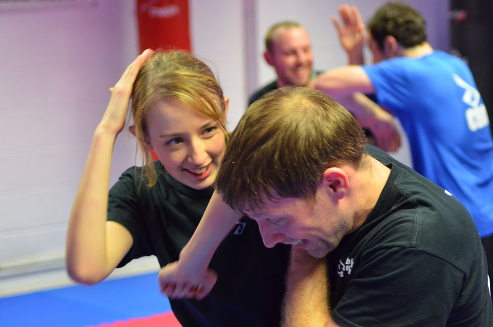 A female engaging a male with elbow strikes in a self defence class