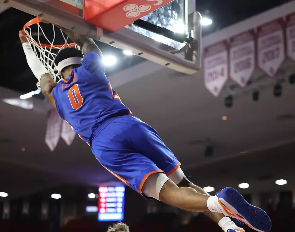 Boogie Fland hangs on the rim after a fast beak dunk (UAA Photo)