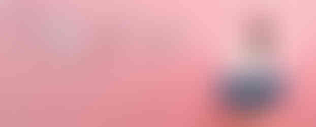 Eine junge Frau sitzt nachdenklich mit ihrem Laptop auf einem Hocker