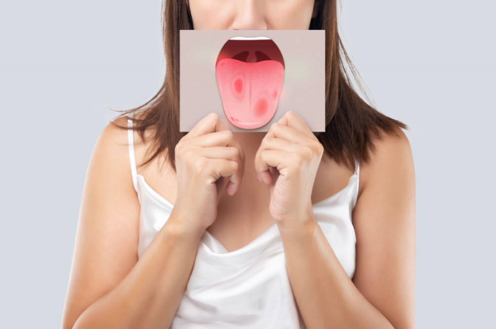 A woman holds an illustration of a tongue up in front of her own mouth.