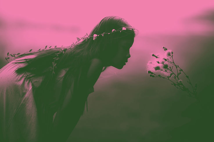 Muchacha que huele las flores