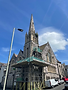 Stone church building with spire and scaffolding