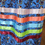 Thumbnail: Detail of multicolour ribbon stack over blue floral motif