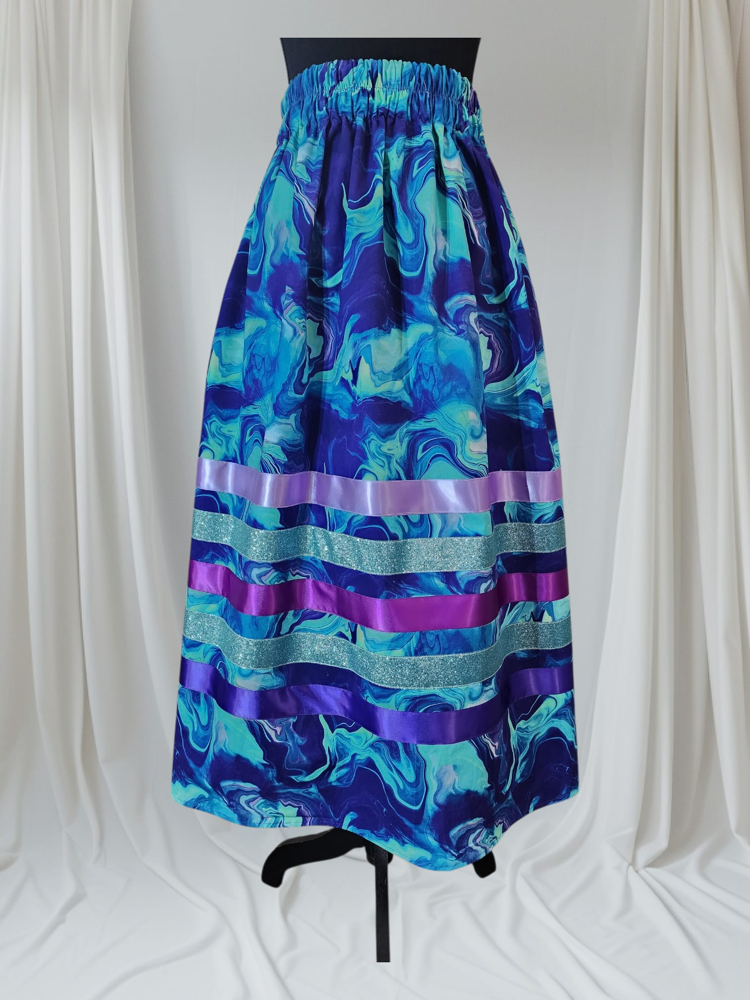 Teal marble print ribbon skirt with purple glitter ribbons, water-inspired Indigenous clothing.