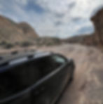A car driving through Aksai canyon in Kyrgyzstan