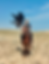 A young Kyrgyzstani boy, riding horseback, holding an eagle in one hand, eagle has wings spread.