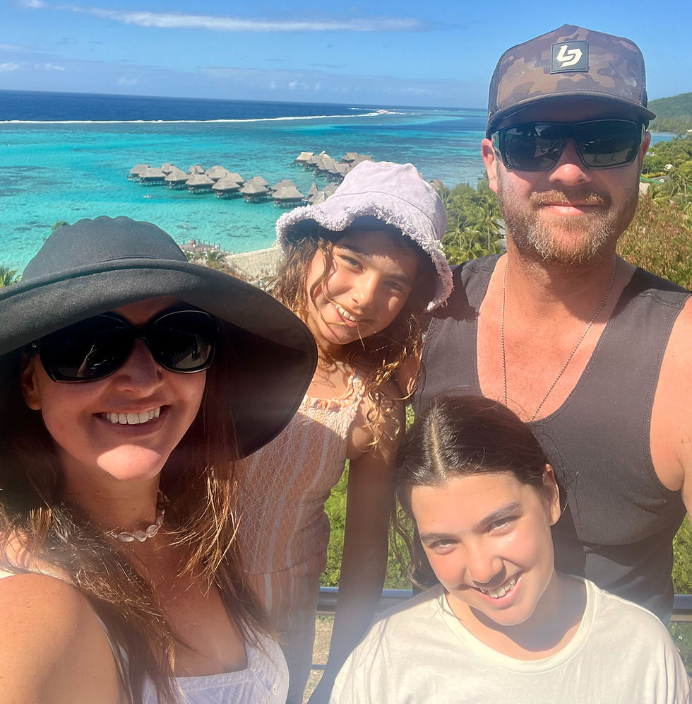 Family on holiday in French Polynesia with turquoise water and over water bungalows