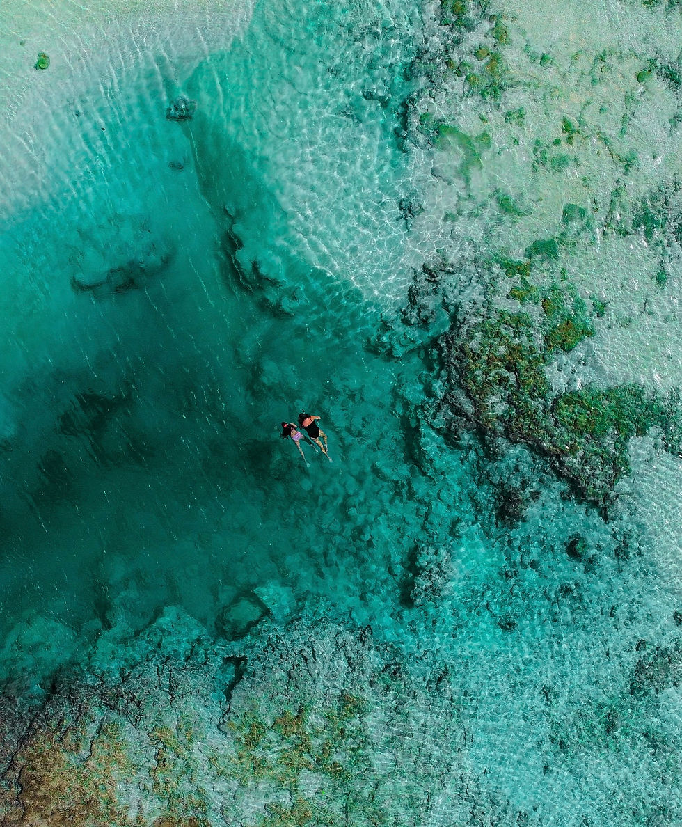 Drone shot from above of family snorkelling in a deep blue rock pool Vanuatu