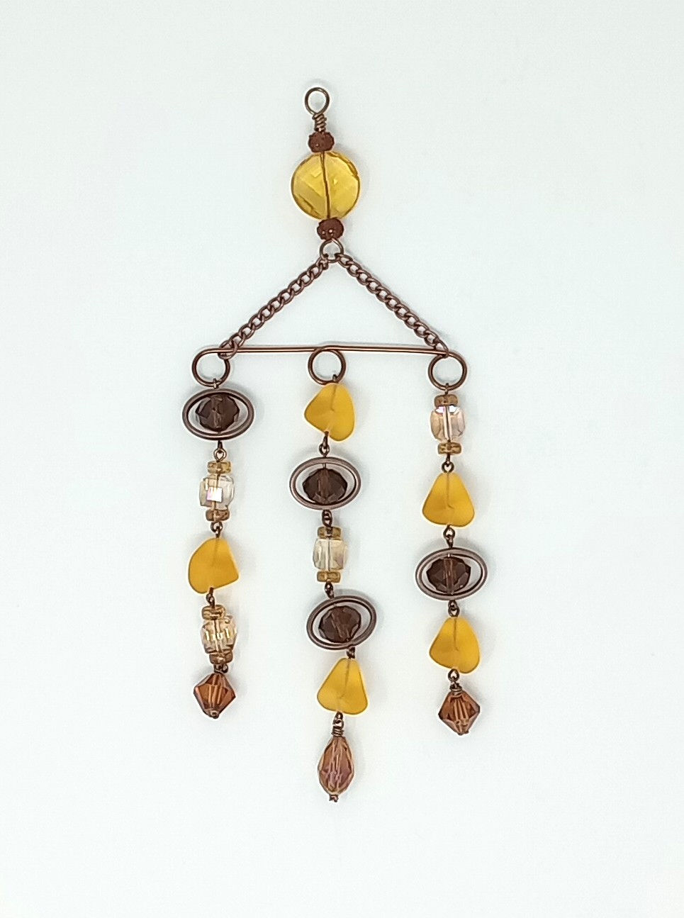 Thumbnail: Handcrafted  suncatcher with three dangling beaded chains. Various shaped crystals and beads in gold, brown and yellow tones.