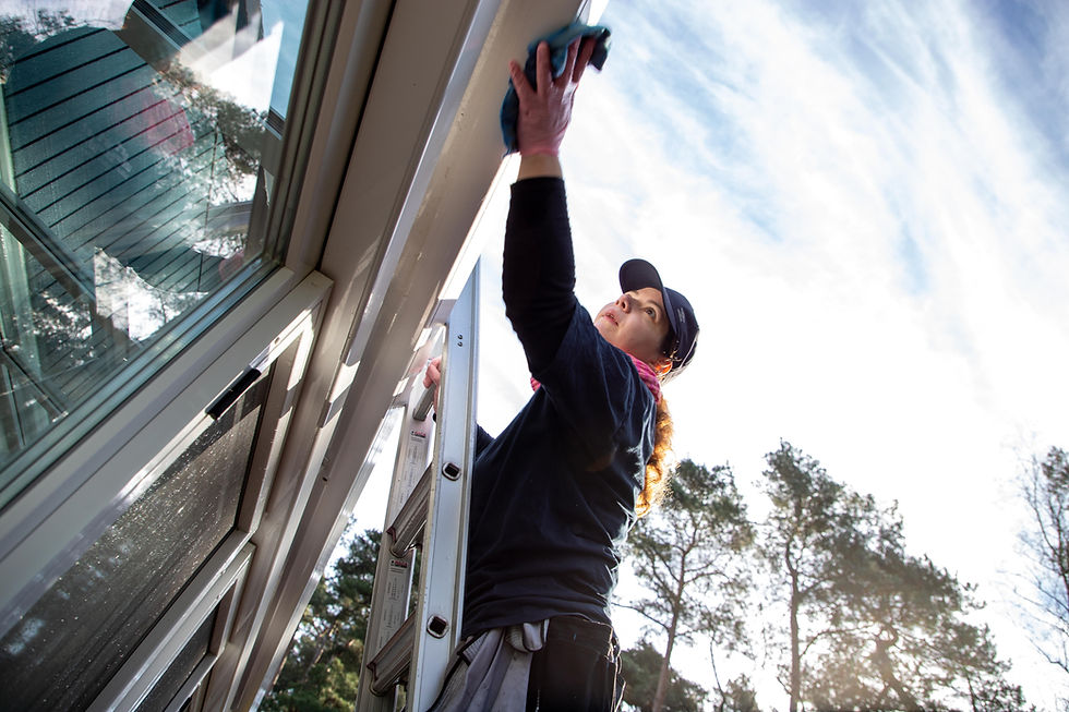 Frau reinigt Dach von Wintergarten