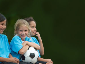 Drei Kinder mit einem Ball in der Hand