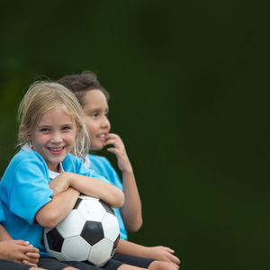 Drei Kinder mit einem Ball in der Hand