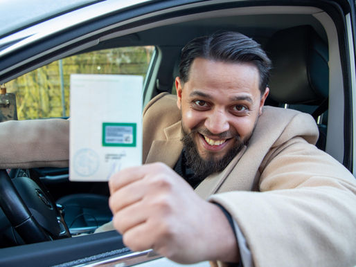 Toni mit Fahrzeugschein in der Hand im auto