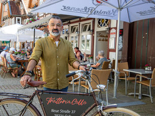 Inhaber Nuri mit Rad vor Trattoria Celle