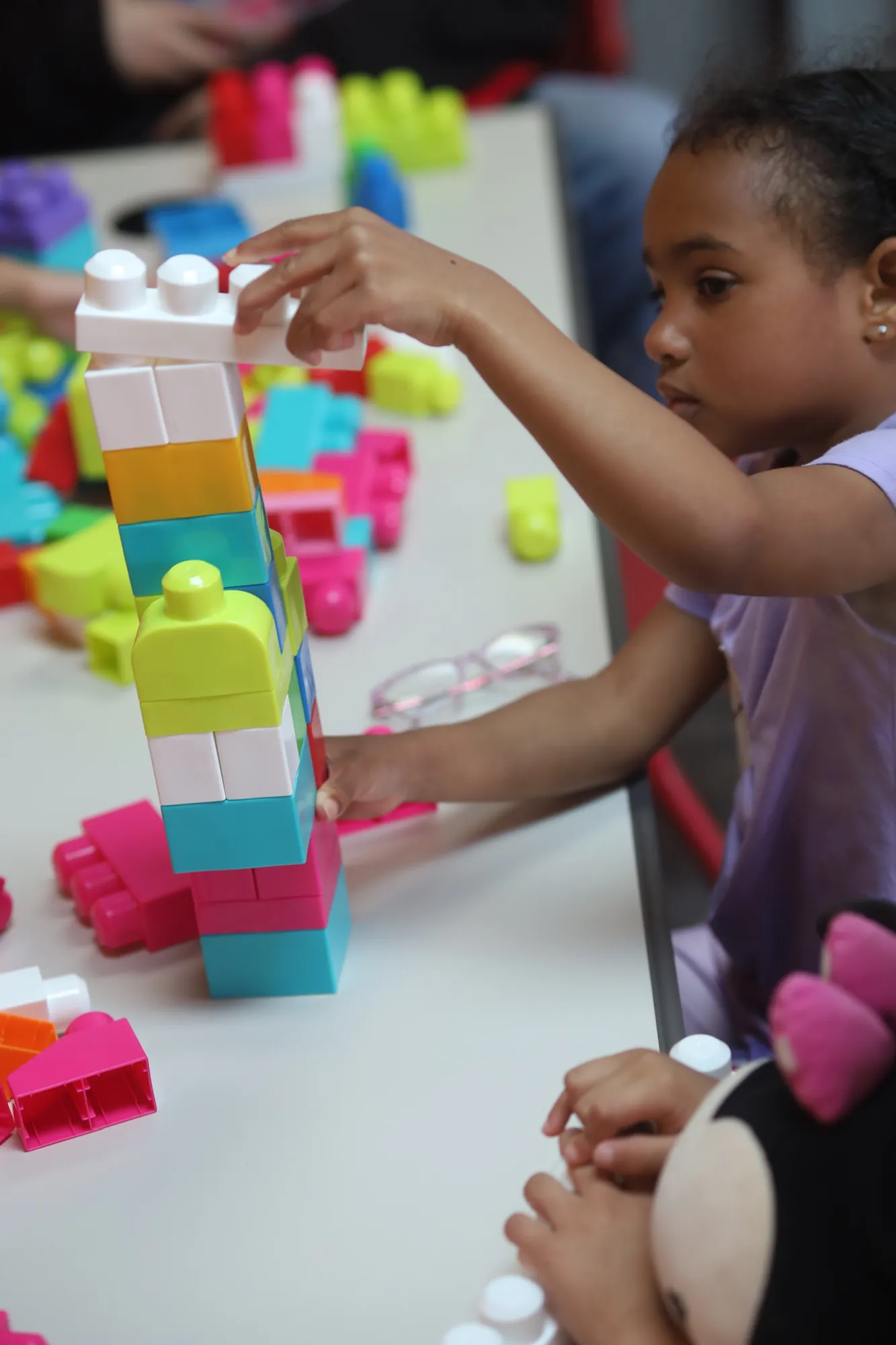A child building with colorful blocks in Kidz Korner