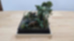 Dinosaur jungle diorama on a wooden table.