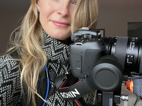 Documentary filmmaker holding a camera while capturing parents and grandparents’ life stories on video.