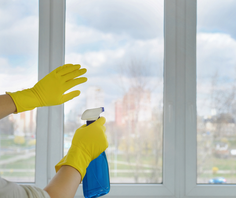 Händer som putsar fönster