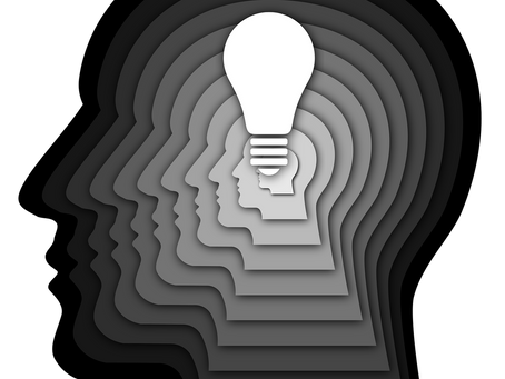Layered silhouettes of a head in shades of gray with a lightbulb in the center, illustrating AI and mental health