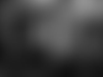 Bald person in grayscale image holds head in hands next to a shattered mirror. The mood is tense, suggesting substance abuse