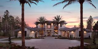 Modern house at sunset with palm trees lining the driveway. Illustrating rent to own luxury.