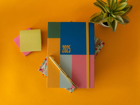 Colorful 2025 planner with geometric design, gold pen, and sticky notes, illustrating marking National Recovery Month 2025.