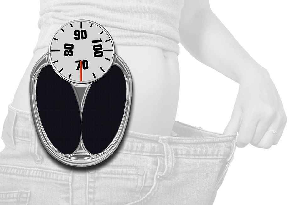 A grayscale image of a woman holding loose jeans, with a scale overlay showing a reading of 70. Indicates PCOS weight loss