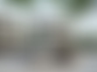 A luxury car with open doors and golf bags in front of modern houses with lush greenery, set on a clear day.